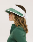A woman wearing a white and green visor with a 'FA' logo on the front.