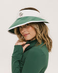 A woman wearing a white and green visor with a 'FA' logo on the front.