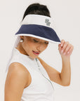 A woman wearing a white and indigo visor with a 'FA' logo on the front and a tied bow on the back.