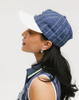 A model wearing a blue and white striped baseball cap with an embroidered logo