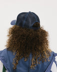 A model wearing an indigo and white hat with the text 'DOUBLE BOGEYS ARE HOT' on the front