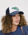A model wearing an indigo and white hat with the text 'DOUBLE BOGEYS ARE HOT' on the front