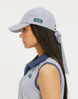 A person wearing a blue and white seersucker baseball cap with the text 'Chasing Balls' embroidered on the front and an oversized bow at the back.