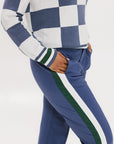 A woman wearing a sleeveless, checkered indigo and white sweater with a mock neck.