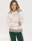 A woman wearing a pink and white checkered intarsia knit sleeveless sweater with a rounded neck.