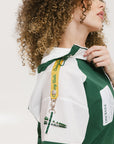 A woman wearing a green and white hoodie with a half-zip design, kangaroo pocket, and decorative woven ribbons.