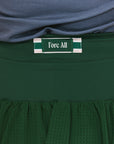 A Fore All tag on the back of a green angel skirt that features a mesh back.