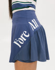 A person wearing a blue skirt with a mesh back, along with a striped top and white socks with green stripes. The image focuses on the skirt which has a sports-inspired design.