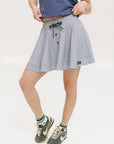 A seersucker skirt with subtle stripes, featuring a flat drawstring, faux buttons down the front, and side seam pockets.