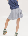 A seersucker skirt with subtle stripes, featuring a flat drawstring, faux buttons down the front, and side seam pockets.