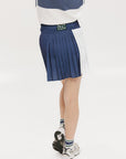 A pleated skirt with colorblocking in indigo and white, featuring a round drawstring cord at the waist and a 'Chasing Balls' icon patch on the back.