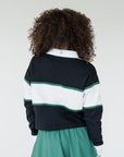 Person wearing a striped sweater and green skirt on a plain background