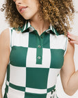 A woman wearing a green and white checkered sleeveless dress with a button placket and side seam pockets.