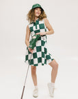 A woman wearing a green and white checkered sleeveless dress with a button placket and side seam pockets.