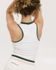 A female model wearing a white sleeveless tank top with a green and pink stripe at the neckline and armholes, and the text 'Chasing Balls' on the chest