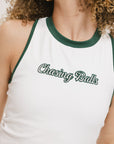 A female model wearing a white sleeveless tank top with a green and pink stripe at the neckline and armholes, and the text 'Chasing Balls' on the chest