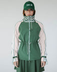 A person wearing a green Elle Rain Jacket with a matching green hat, standing against a white background.