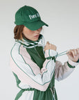 A person wearing a green Elle Rain Jacket with a matching green hat, standing against a white background.