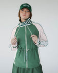 A person wearing a green Elle Rain Jacket with a matching green hat, standing against a white background.
