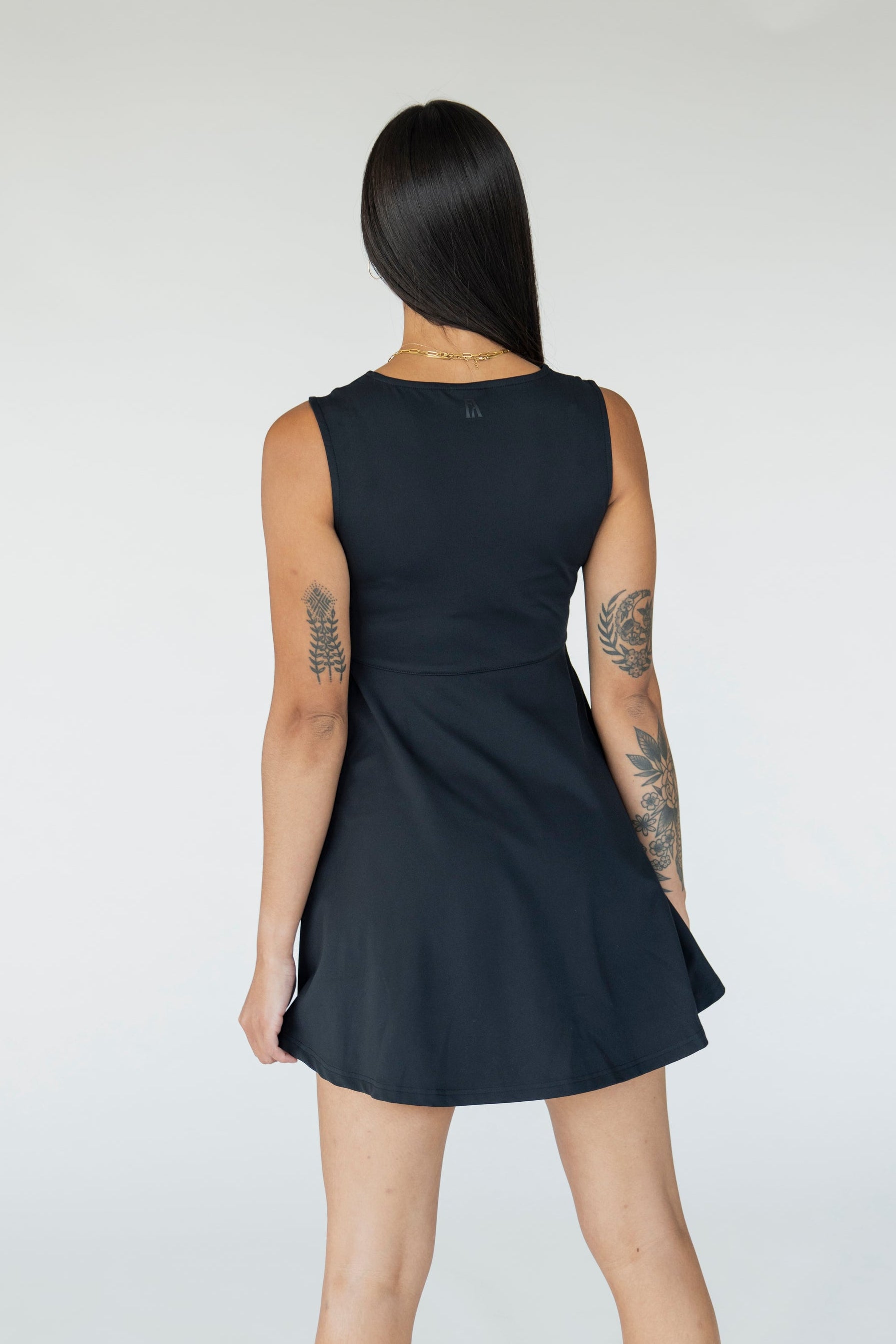 Woman wearing a black sleeveless dress on a white background