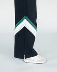 A model wearing a black sweatpant with green and white stripe details, paired with a matching sweatshirt.