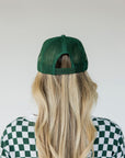 Green and white cap with 'Golfing Optional.'