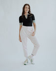 cute women’s golf pants that are pink on a white back ground. Styled with black golf polo.