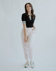 cute women’s golf pants that are pink on a white back ground. Styled with black golf polo.