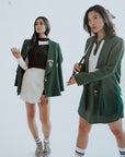 Two girls wearing meg blazers in green.
