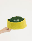 Green and avocado cap with 'FORE' text held by a hand on a white background