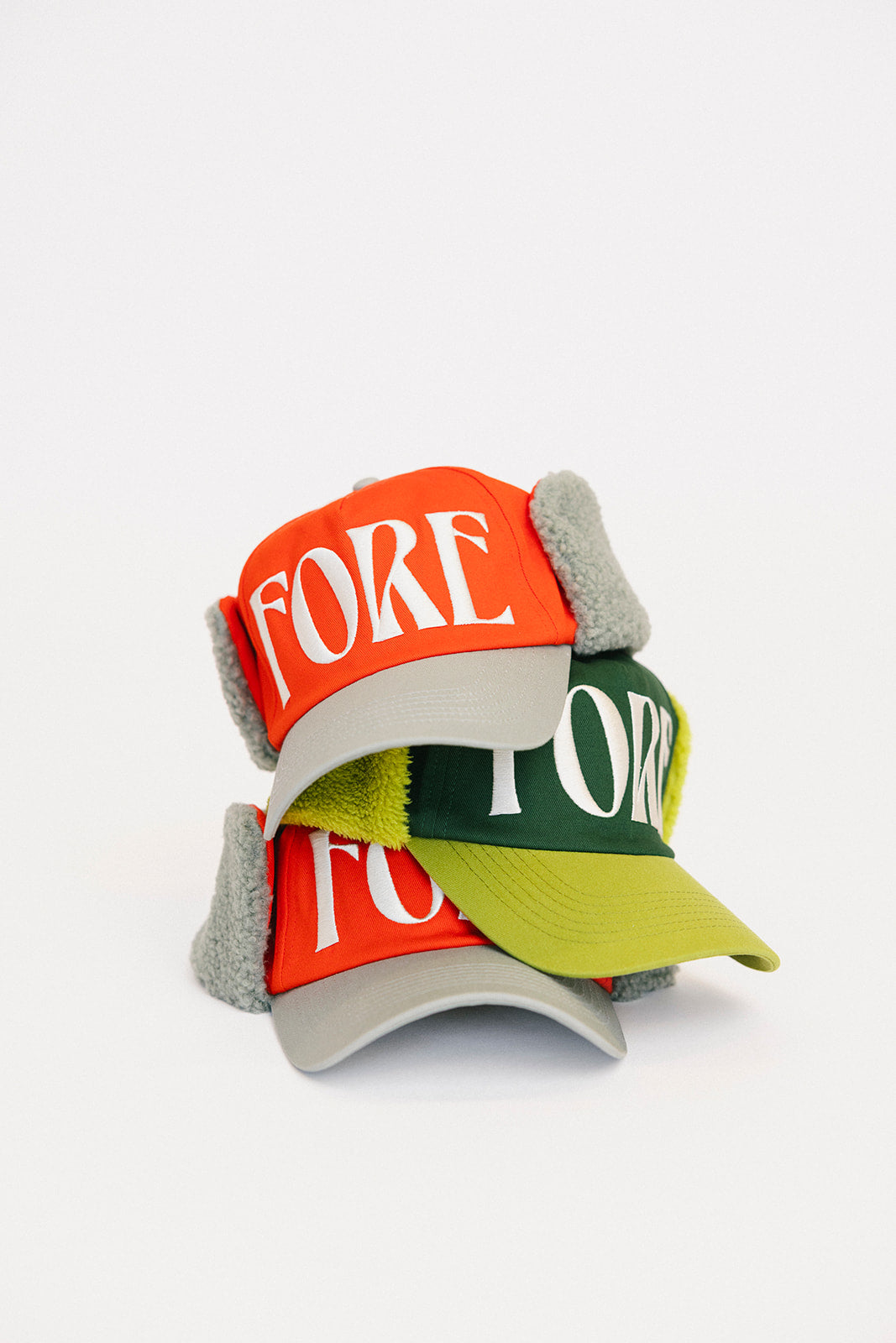 Stack of three caps with 'FORE' and 'FORE' text on a white background