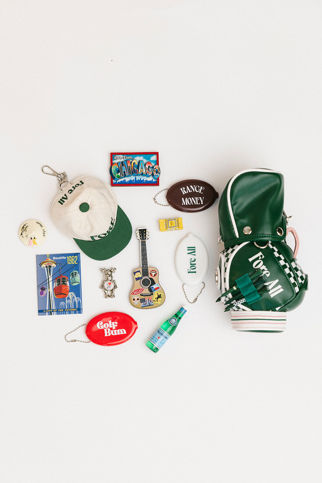 Collection of various small items including a hat, keychain, and magnets on a white background