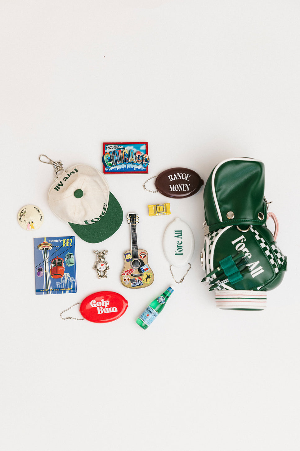 Collection of various small items including a hat, keychain, and magnets on a white background