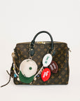 Designer handbag with colorful charms on a white background
