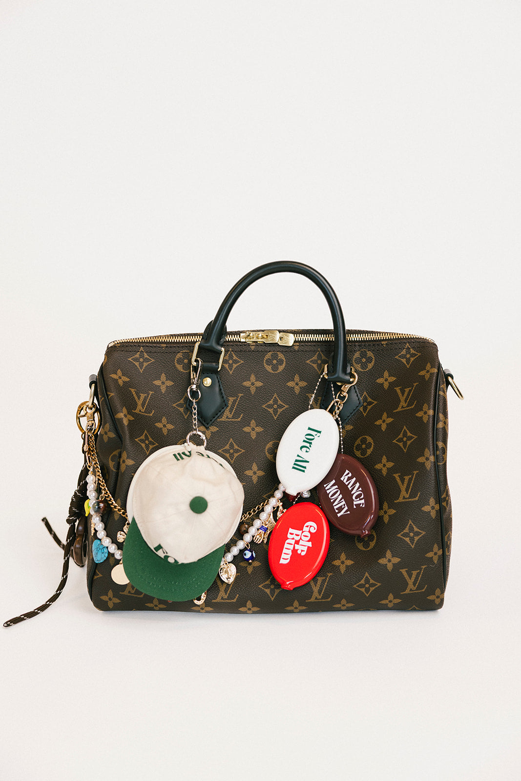 Designer handbag with colorful charms on a white background