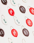 Set of oval-shaped keychains with text on a light background
