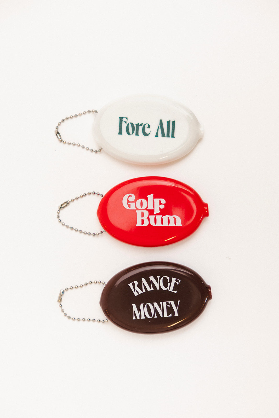 Three oval keychains with humorous text on a white background