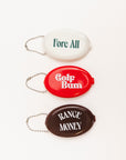 Three oval keychains with humorous text on a white background