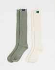 Two pairs of knee-high socks, one green and one white, on a light gray background.