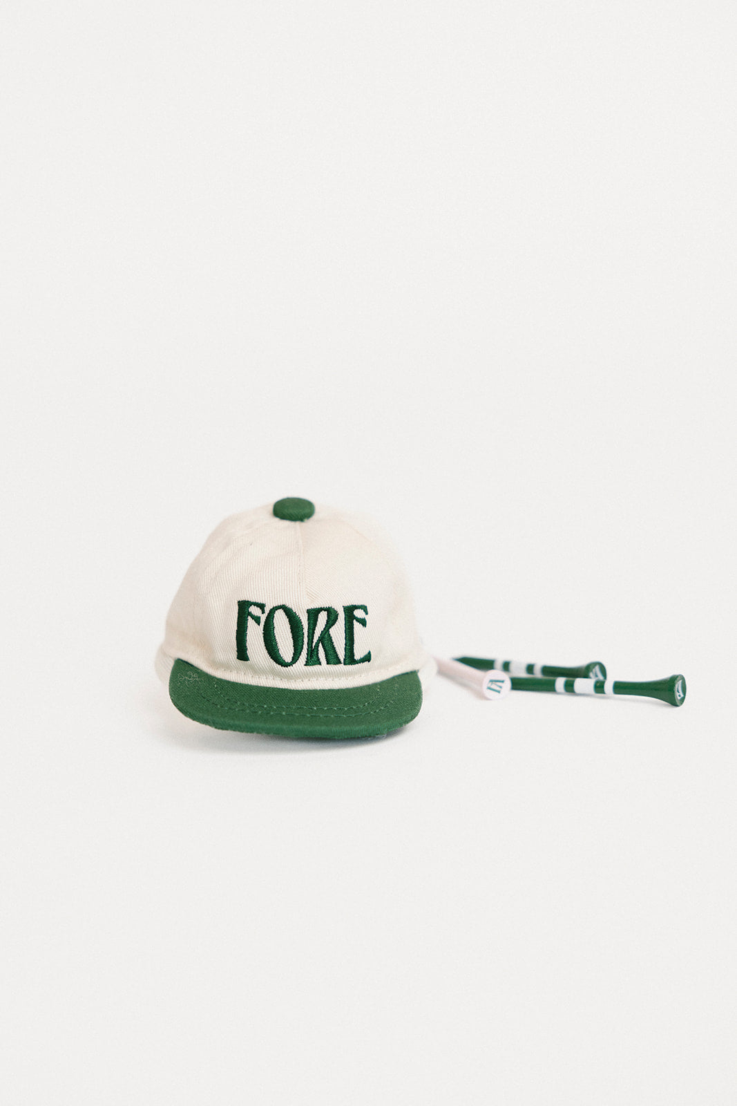 White cap with green brim and 'FORE' text on a white background