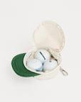 Canvas bag with golf balls and a green cap on a white background