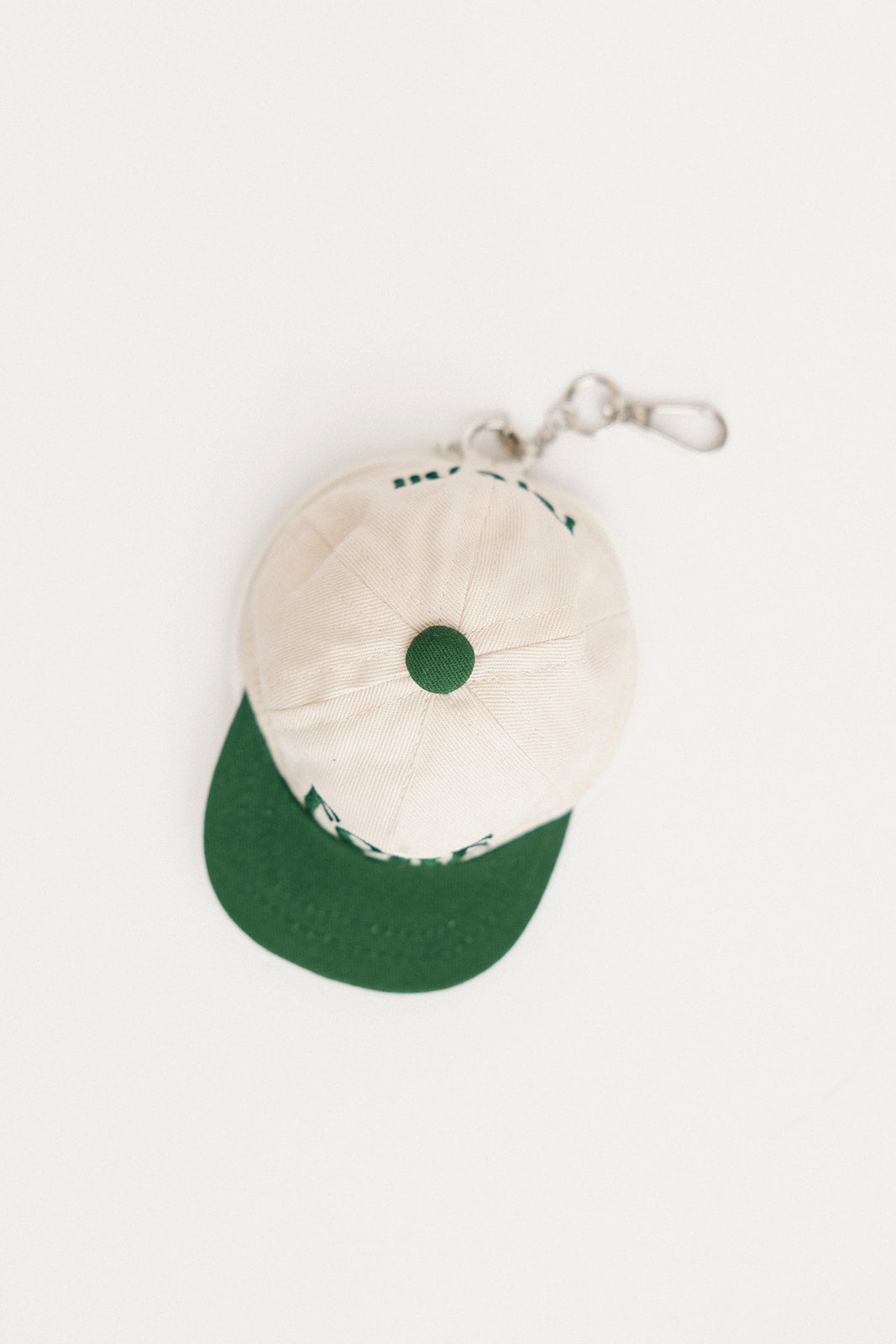 White cap with green brim and logo on a white background
