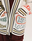 Person wearing a patterned cardigan with text and numbers on a white background