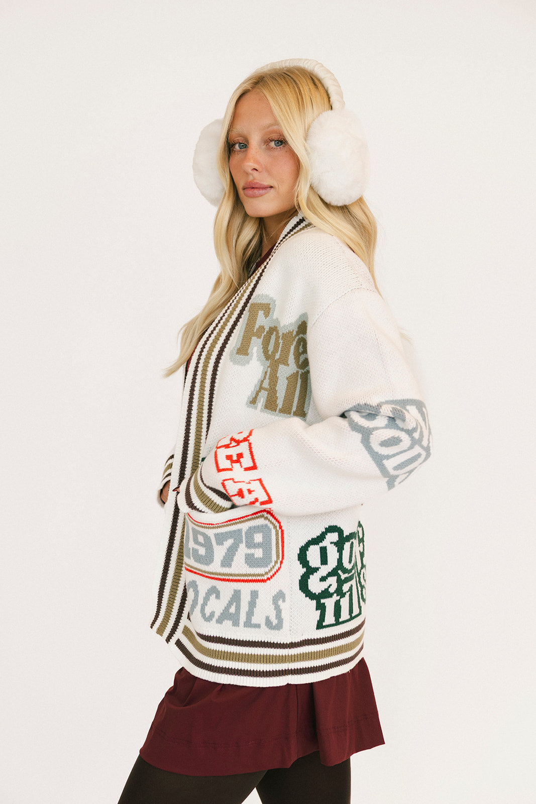 Woman wearing a patterned cardigan with text and graphics on a white background