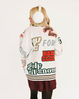 Person wearing a sweater with colorful text and designs on a white background