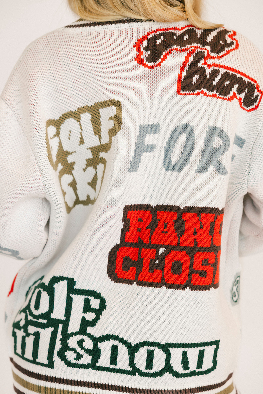 Close-up of a sweater with text and brand logos on the back