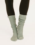 Light gray ribbed socks worn with black leggings on a white background