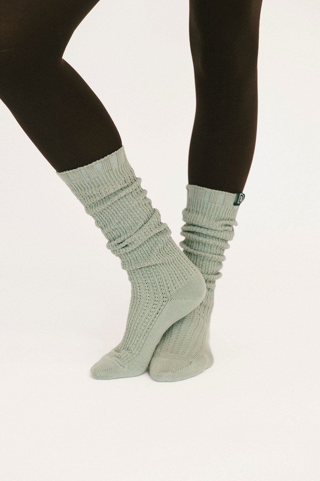 Light gray socks worn with black leggings on a white background