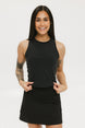 A smiling woman wearing a black tank top with a built-in bra, posing against a white background.