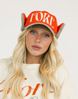 Person wearing a red cap and a white sweatshirt with red text on a light background